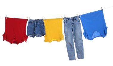 Different clothes drying on laundry line against white background