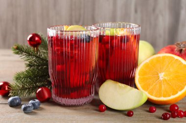 Bardaklarda, malzemelerde ve Noel dekorunda ahşap masada Aromatik Sangria içeceği.