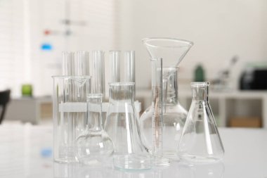 Laboratuvar analizi. Beyaz masa içerisindeki farklı camlar.