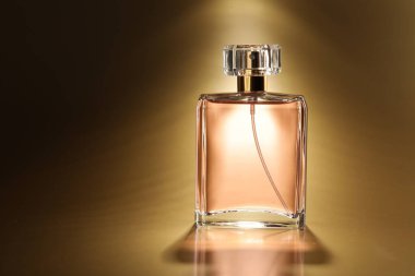 Lüks kadın parfümü. Altın arka planda güneş ışığı şişesi, metin için boşluk