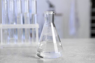 Laboratuvar analizi. Açık gri masadaki matara ve test tüpleri kapalı.