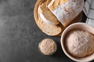 Taze ekşi ekmek, hamur ve ekmek gri masada, üst tarafta. Metin için boşluk