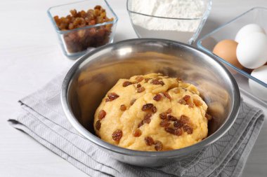 Kuru üzümlü hamur ve beyaz ahşap masa malzemeleri.