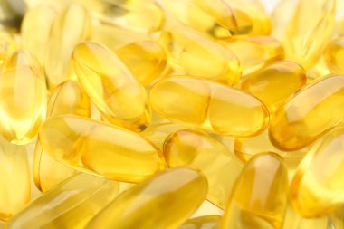 Arkaplan olarak birçok sarı vitamin kapsülü, yakın plan