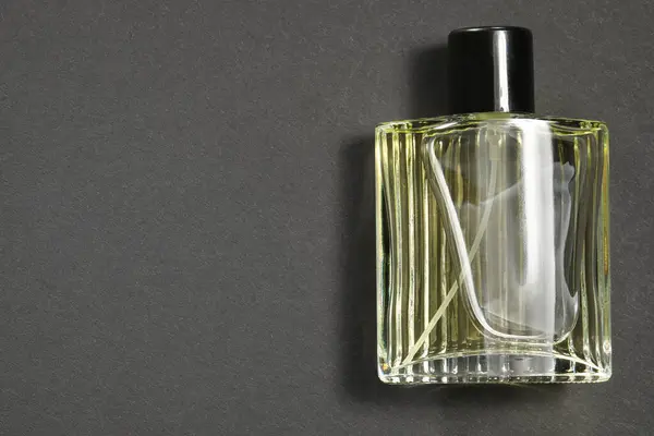 Luxury men`s perfume in bottle on black background, top view. Space for text
