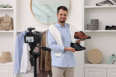 Gülümseyen moda blogcusu evde video kaydederken ayakkabılarını gösteriyor