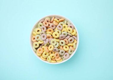 Açık mavi masada kasede leziz mısır gevreği halkaları.