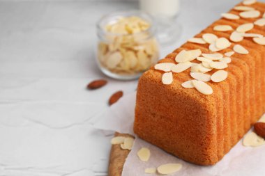 Beyaz desenli masada taze badem taneli kek, yakın plan. Metin için boşluk