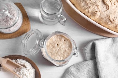 Ekşi ekmek, cam kavanozda, un, hamur ve su aydınlatma masasında, düz bir şekilde yatıyordu.