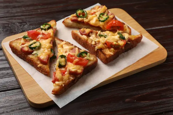 Tasty pizza toasts served on wooden table