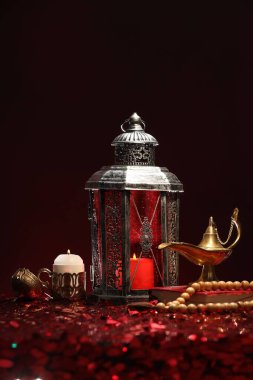 Arap feneri, Kur 'an, Misbaha, yanan mum ve parlak kırmızı masada Aladdin sihirli lamba.