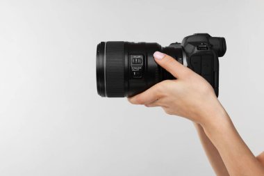 Açık gri arka planda kamerası olan fotoğrafçı, yakın plan. Metin için boşluk