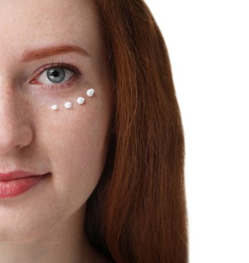 Yüzünde çilli ve krem rengi beyaz arka planda güzel bir kadın, yakın plan.