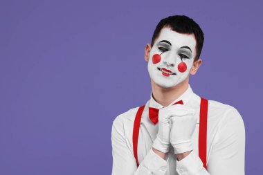 Mor arka planda poz veren komik pandomimci. Metin için boşluk