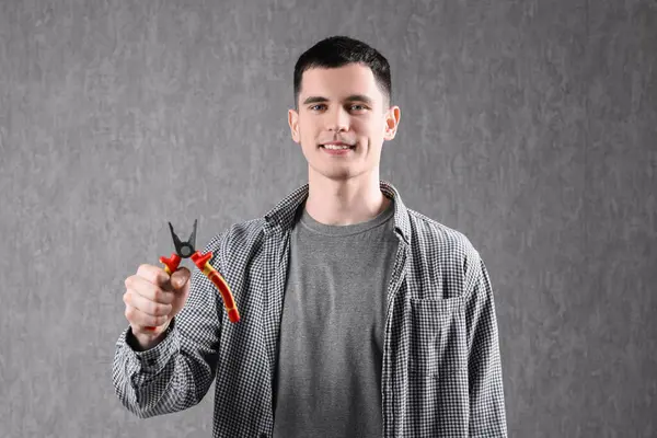 Young Man Holding Pliers Grey Background — Stock Photo, Image