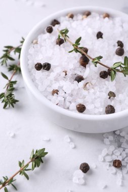 Kekikli tuz ve beyaz mermer masada kasede biber.