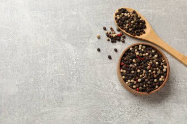 Aromatik baharat. Farklı biberler kasede ve kaşık gri masada, üst manzara. Metin için boşluk