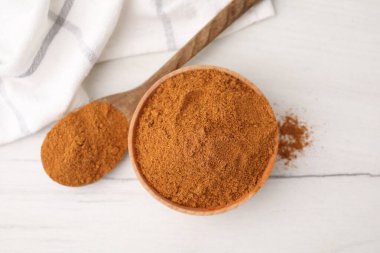 Aromatik baharat. Kavanozda kırmızı biber, beyaz ahşap masada kaşık, üst manzara.