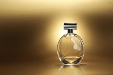 Lüks kadın parfümü. Altın arka planda güneş ışığı şişesi, metin için boşluk