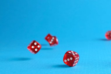 Açık mavi arkaplana düşen birçok kırmızı oyun zarı