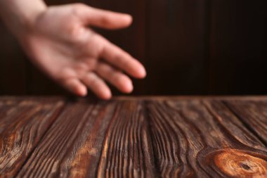 Ahşap masanın üstünde el ele tutuşan kadın, seçici bir odak noktası. Metin için boşluk