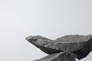 Ürün sunumu. Açık gri arkaplanda taşlardan yapılmış bir podyum. Metin için boşluk