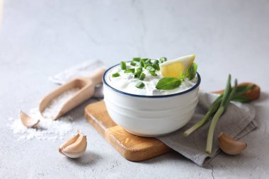 Tabakta yeşil soğanlı lezzetli yoğurt, sarımsak, tuz ve limon.