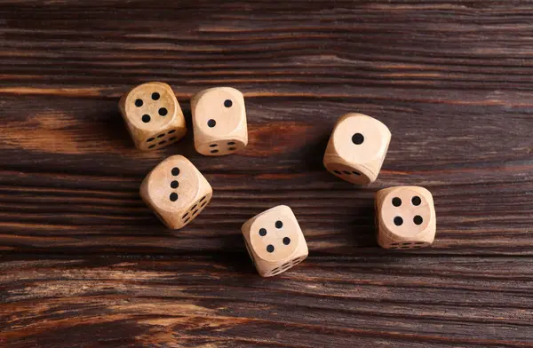 Many game dices on wooden table, flat lay