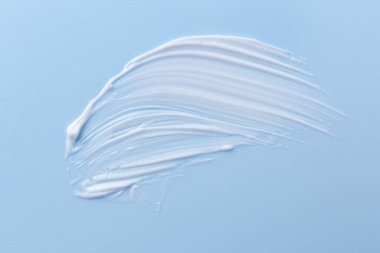 Açık mavi arka planda vücut bakım kremi örneği, üst görünüm