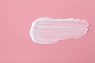 Pembe arka planda vücut bakım kremi örneği, üst görünüm.