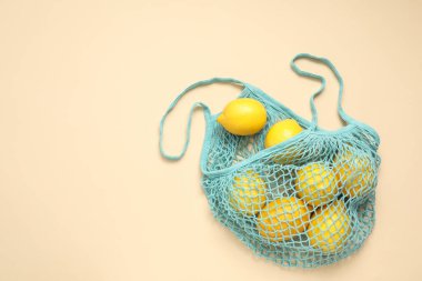 Bej arka planda taze limonlu ip torbası, üst manzara. Metin için boşluk