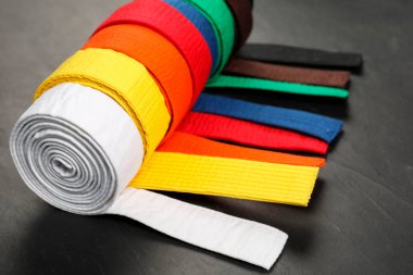 Gri arkaplanda renkli karate kemerleri, yakın plan