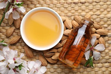 Badem yağı kasede, şişede, fındıkta, çiçeklerde ve yapraklarda hasır masada, düz yerde