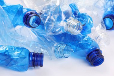 Kırışmış tek kullanımlık plastik şişeler beyaz arka planda