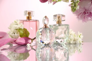 Ayna yüzeyinde pembe arka planda lüks parfümler ve çiçek dekoru