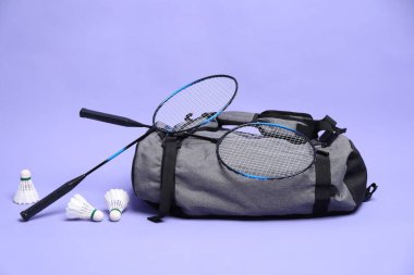 Tüy badminton mekik horozları, raketler ve çanta menekşe arka planda