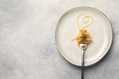 Kalp, spagetti ve çatalla yapılmış gri masa, üst manzara. Metin için boşluk