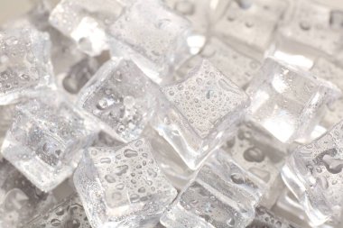 Arkaplan olarak su damlaları ile eriyen buz küpleri, yakın plan