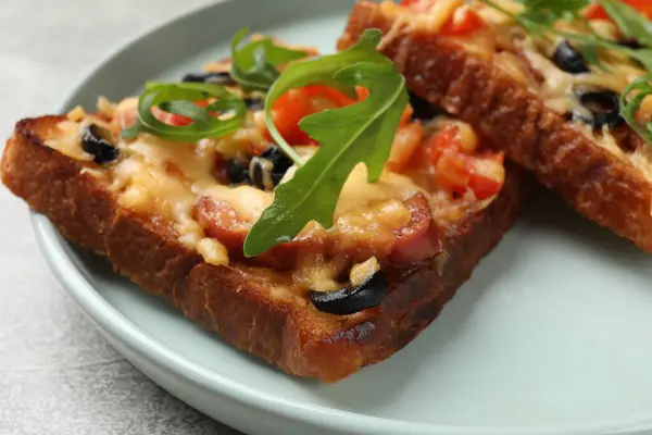 Tasty pizza toasts served on grey table, closeup