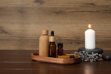 Aromaterapi ürünleri, yanan mum ve lavanta, ahşap masa, metin için yer