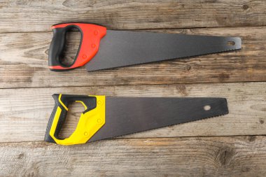 Ahşap zemin üzerinde renkli saplı testereler, düz yatıyordu