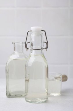 Cam şişelerde sirke ve ışık masasında tencere.