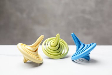 Beyaz masanın üzerinde parlak dönen kapaklar, yakın plan