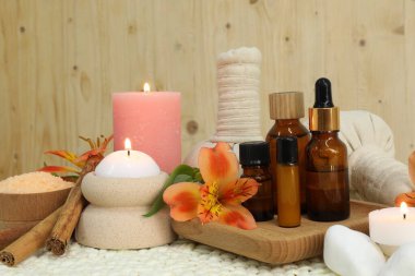 Different aromatherapy products and burning candles on table clipart