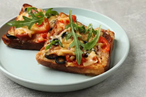 Tasty pizza toasts served on grey table, closeup