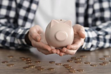 Finansal tasarruflar. Ahşap masada kumbaralı bir adam