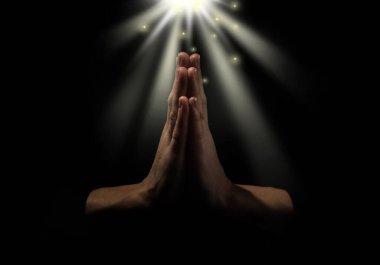 Karanlıkta kutsal ışığın altında el ele tutuşan Hristiyan kadın, yaklaş. Dua ve inanç.