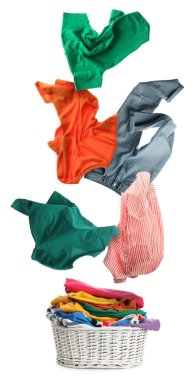 Çamaşır sepetinin üzerinde beyaz arka planda giysiler