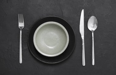 Siyah masasında parlak çatal bıçak takımı olan şık bir ortam.