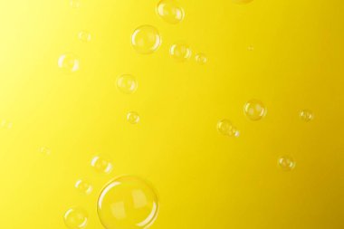 Sarı arka planda güzel şeffaf sabun köpükleri
